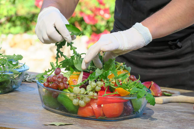 Hände des Küchenchefs bereiten Schüssel mit frischem Obst und Gemüse in Chania, Beton, Griechenland. — Stockfoto