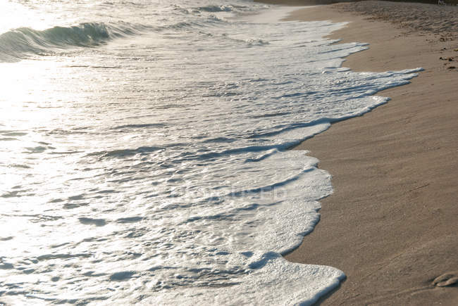 Куба, Рафаэль Фрейре, море в Холигене, волны на песчаном берегу на закате — стоковое фото