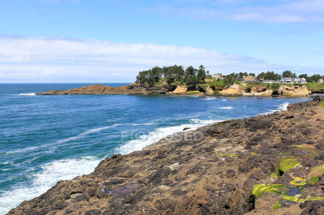 Estados Unidos, Oregon, Arch Cape, paisaje marino con sol en la costa rocosa - foto de stock