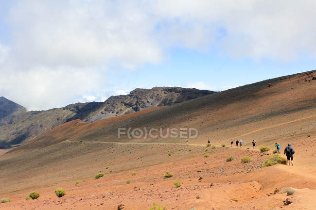 EEUU, Hawái, Kula, Grupo de turistas caminando dentro de un cráter volcánico - foto de stock