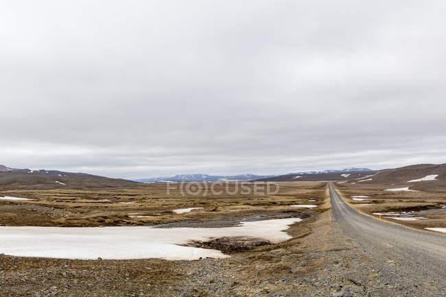 Nevado paisaje llano con carretera, Islandia - foto de stock
