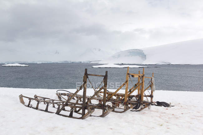 Antártida, los pingüinos yacen junto a los trineos en la bahía helada - foto de stock