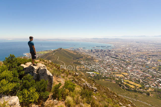 South Africa, Western Cape, Man enjoying Cape Town aerial view from Table Mountain National Park, cityscape by the ocean coast in sunshine — Stock Photo