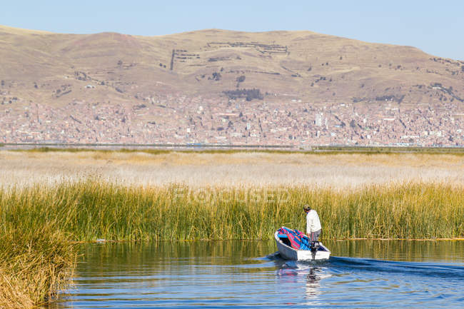 Perù, Puno, Puno, uomo in barca sul lago Titikaka - Isola di Uros — Foto stock