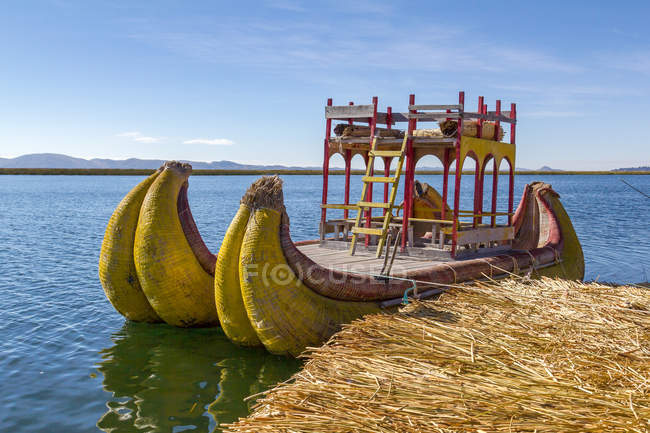Perú, Puno, Puno, Lago Titikaka, barco tradicional amarrado por el muelle - foto de stock