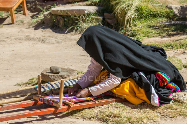 Donna che lavora sulla strada del villaggio al Lago Titicaca delle Isole Uros, Puno, Perù — Foto stock