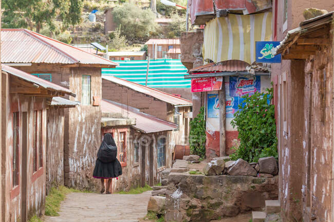 Femme marchant dans la rue du village au lac Titicaca des îles Uros, Puno, Pérou — Photo de stock