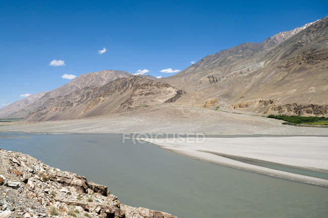 Tajiquistão, rio largo em frente às montanhas — Fotografia de Stock