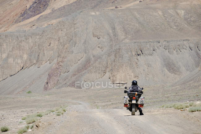 Tajikistan, man on motorcycle in side valley near Murghab — Stock Photo