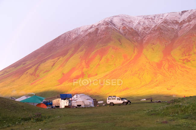 Quirguistão, região de Osh, pôr do sol no acampamento de iurtes, vista panorâmica das montanhas — Fotografia de Stock