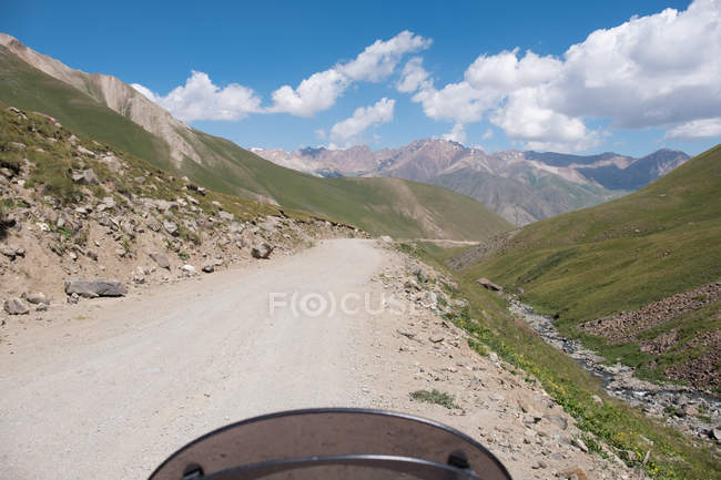 Kirguistán, Región de Naryn, Distrito de Kochkor, camino de tierra a las laderas de las montañas - foto de stock