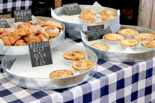 Homemade pastries with price tags on checkered tablecloth at Granger Bay Market, Western Cape, Cape Town, South Africa — Stock Photo