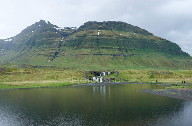 Islândia, Snefellsnes, paisagem cênica com Kirkjufellsfoss Cachoeira junto ao lago da montanha — Fotografia de Stock