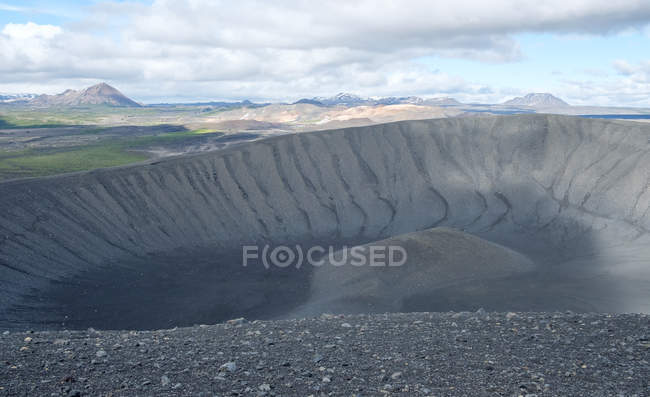 Parte del cráter Hverfjall y paisaje montañoso bajo el cielo nublado, Islandia - foto de stock
