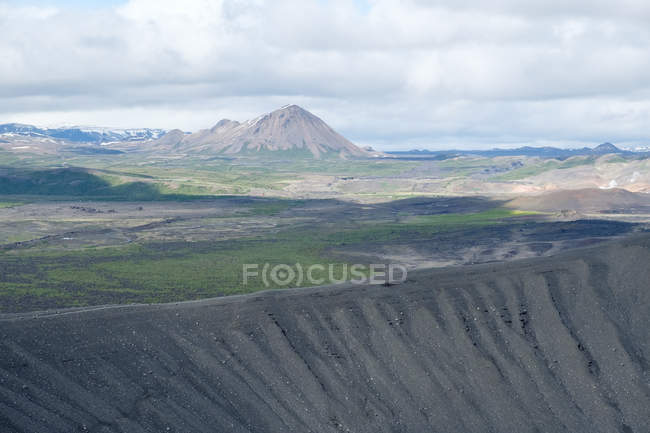 Часть кратера Hverfjall и горный ландшафт под облачным небом, Исландия — стоковое фото