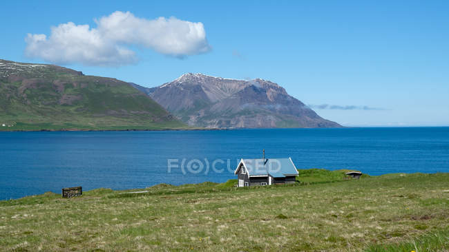 Pequeno edifício na costa e montanhas distantes, Islândia, Borgarfjordur — Fotografia de Stock