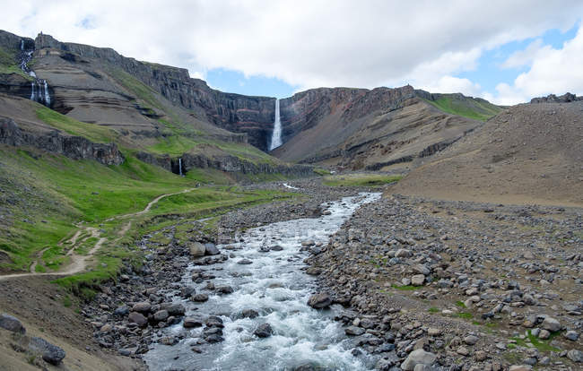 Vista panorámica de la cascada de Hengifoss y el arroyo en primer plano - foto de stock