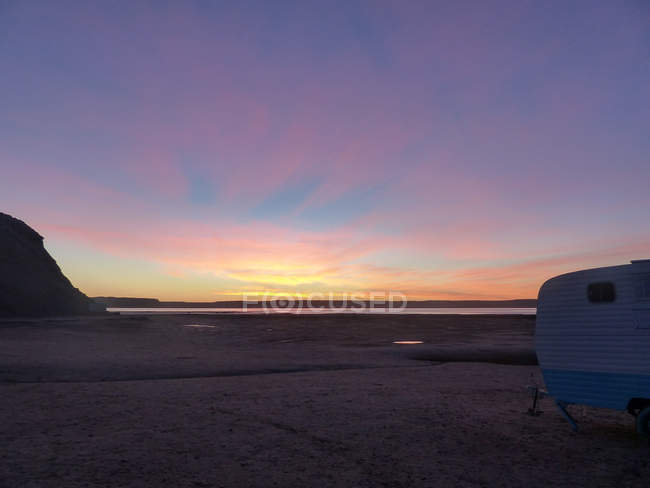 Argentina, Chubut, Viedma, Península Valdez, puesta de sol en una bahía con vistas a las caravanas - foto de stock