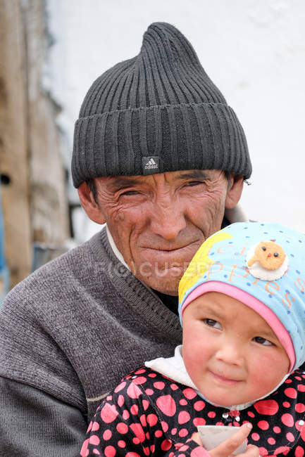 Portrait of Grandpa with granddaughter at village street in Tajikistan — Stock Photo