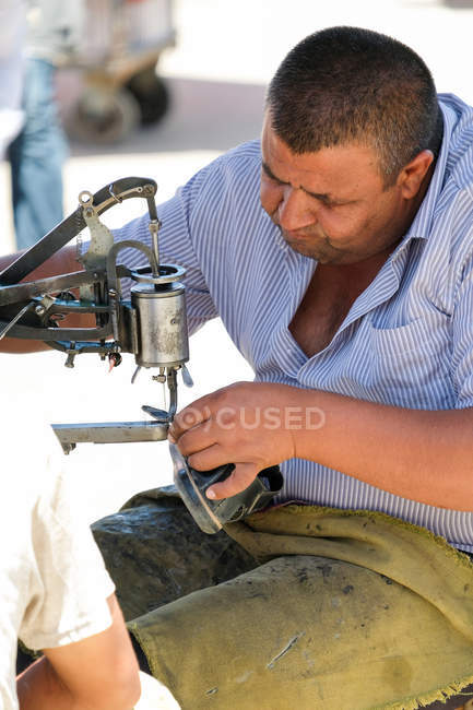 Uzbekistan, man repairing shoes at market — Stock Photo