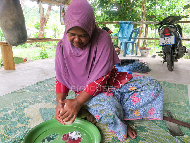Взрослая женщина режет кокос, Тамбон Хуекхак, Чанг Ват Пханг-нга, Таиланд — стоковое фото