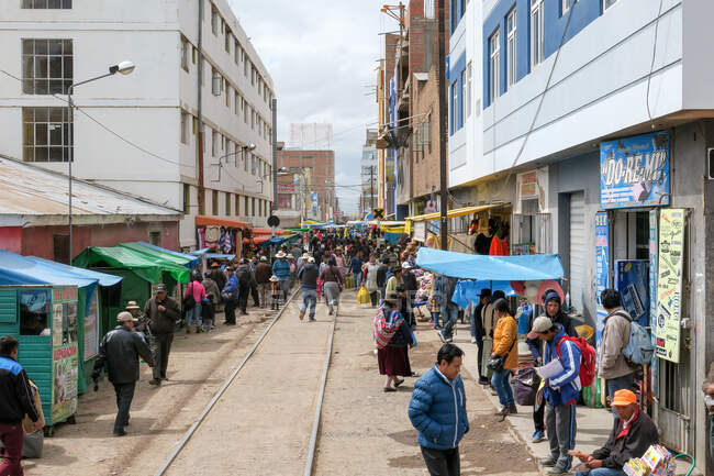 Local people walking by street stores in Juliaca, Puno, Peru — Stock Photo