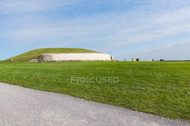 Irlanda, Condado de Meath, Newgrange, Zona verde frente a la colina, Newgrange (Gran cima del Neolítico), Calzada - foto de stock