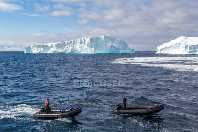 Menschen in Booten beobachten Eisberg im Wasser voraus, Antarktis — Stockfoto