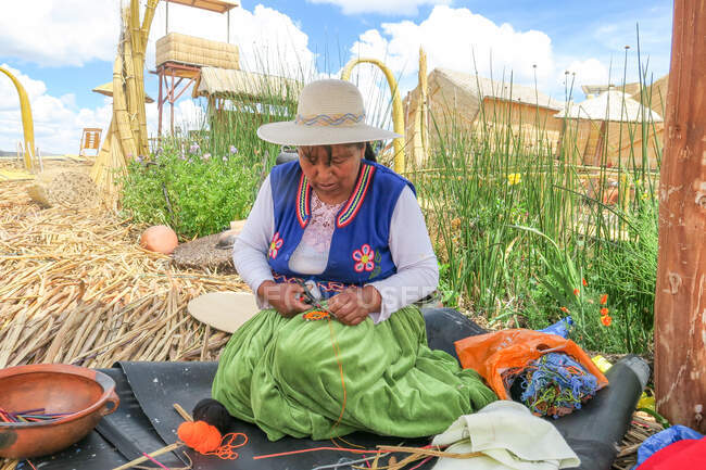 Woman handworking on shore of Uros Islands by Lake Titicaca, Puno, Peru — Stock Photo