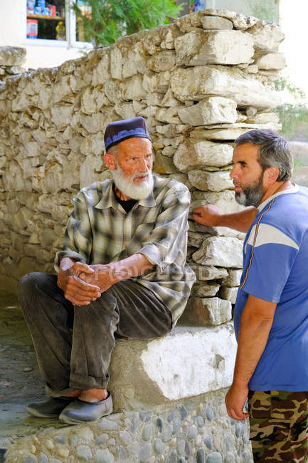 Dos hombres locales hablando al aire libre, Tayikistán - foto de stock
