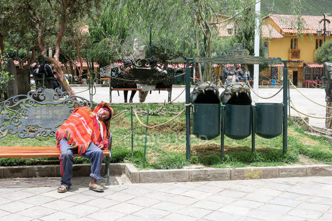 Перу, Qosqo, Ollantaytambo, Sleeping man on bench in Ollantaytambo — стоковое фото