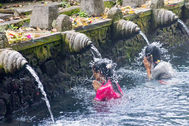 Indonésie, Bali, Gianyar, Femmes priant dans l'eau du temple hindou Pura Tirta Empul — Photo de stock