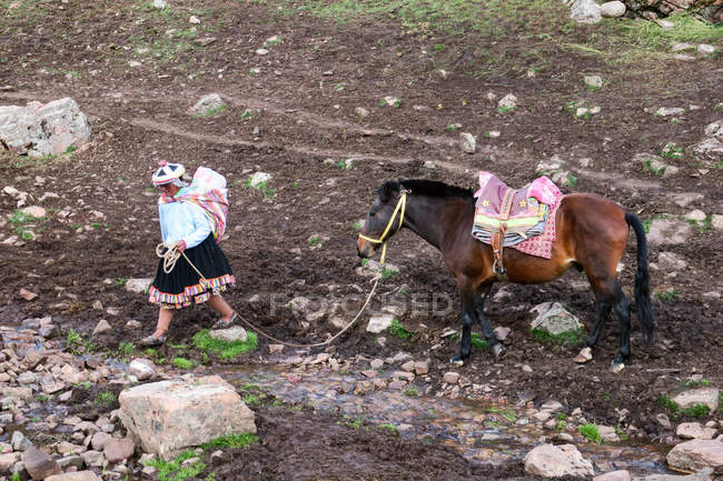 Vista ad alto angolo della nativa peruviana che cammina con il cavallo a Cusco, Qosqo, Perù . — Foto stock