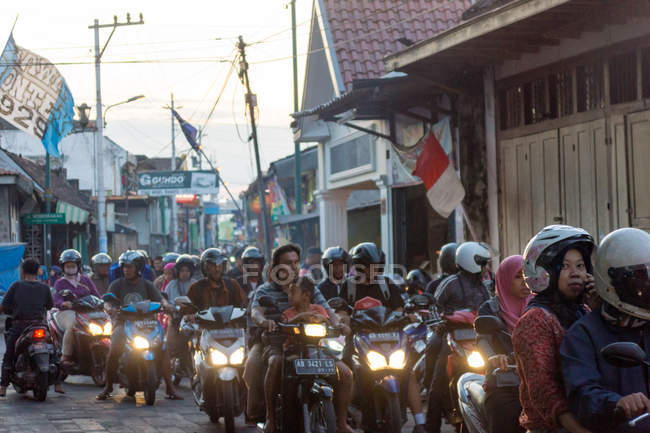 Street scenery with road traffic on scooters in evening with lights in Yogyakarta, Java, Indonesia, Asia — Stock Photo
