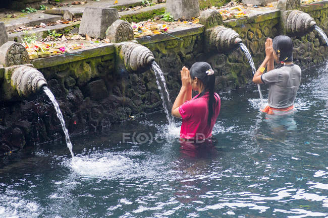 Indonésie, Bali, Gianyar, Femmes priant dans l'eau du temple hindou Pura Tirta Empul — Photo de stock