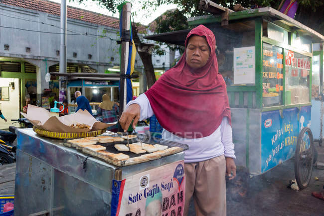 Paisagem de rua com vendedora feminina no stand de comida de rua em Yogyakarta, Java, Indonésia, Ásia — Fotografia de Stock