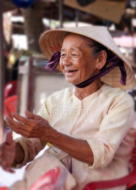 Mature lady with Vietnamese cone hat at street market, Thanh pho Hoi An, Quang Nam Province, Vietnam — Stock Photo