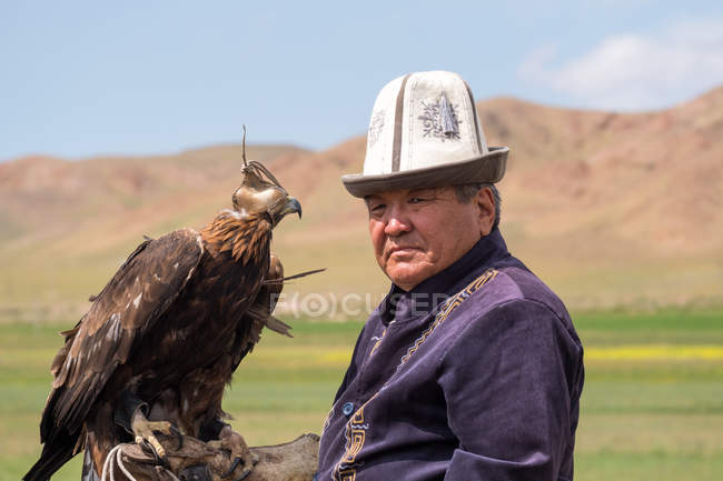 Cacciatore d'aquila con aquila reale sulla mano maschile, Ak Say, regione Issyk-Kul, Kirghizistan — Foto stock