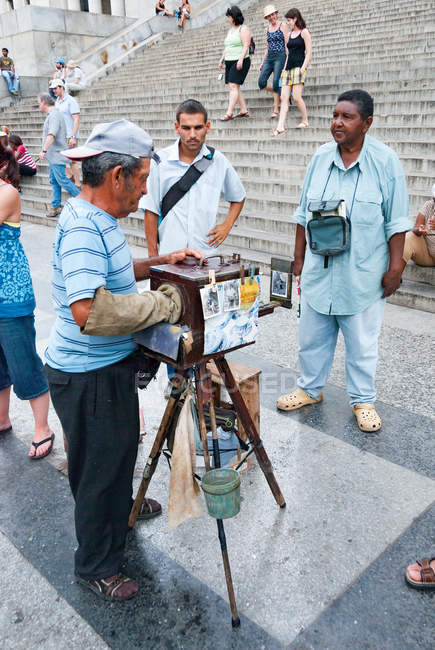 Alter mann fotograf mit alter kamera vor hauptstadt, havana, kuba — Stockfoto