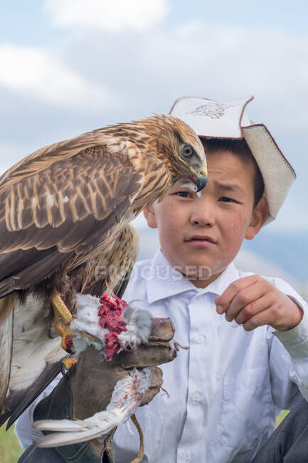 Kirguistán, región de Issyk-Kul, Ak Say, Boy with eagle, Nomad Games. - foto de stock