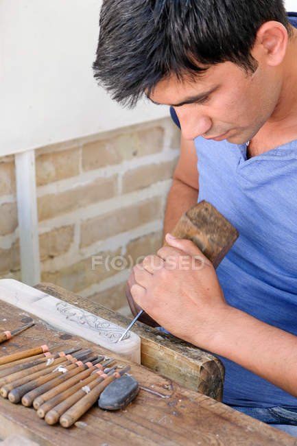 Primer plano de artesano con herramientas tallando ornamento, Buxoro, Uzbekistán - foto de stock