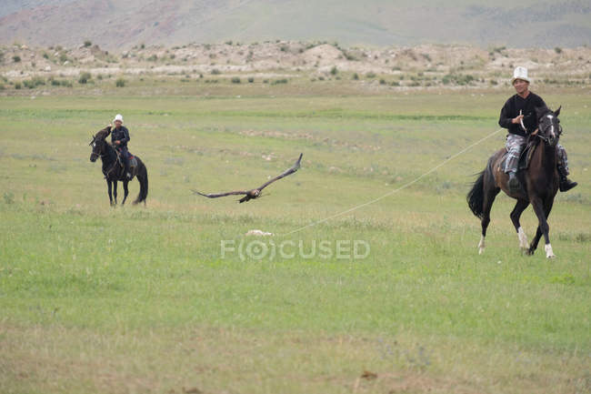 Ak say, issyk-kul region, Kyrgyzstan - 12. August 2017: Vorführung von Adlerjägern, Männern auf Pferden — Stockfoto