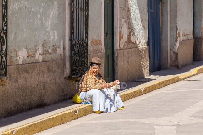 Mujer peruana con sombrero tradicional en calle ciudad, Julio, Puno, Perú - foto de stock
