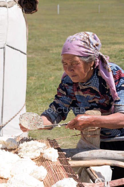 Старуха готовит Курут на открытой кухне, Кочкор, Кыргызстан — стоковое фото