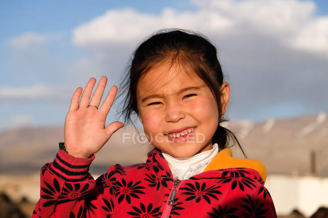 Menina asiática sorrindo acenando à mão na câmera, Tajiquistão — Fotografia de Stock