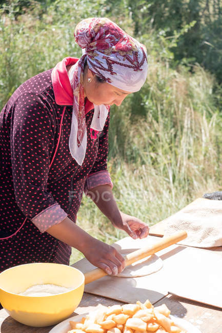 Donna stendere pasta in cucina all'aperto, Ak Say, Kirghizistan — Foto stock