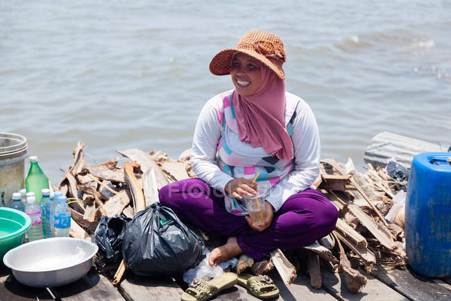 Femme riant sur du bois de chauffage au marché aux crabes, Kep, Cambodge — Photo de stock