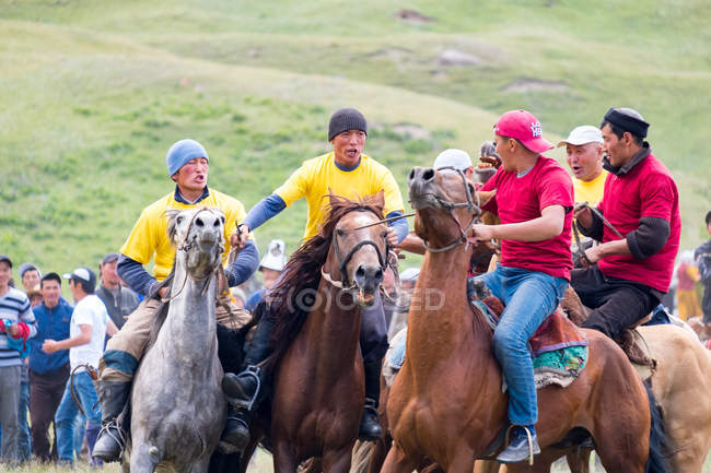 Región OSH, KYRGYZSTAN - 22 de julio de 2017: Nomadgames, Hombres locales a caballo, participantes en polo de cabra - foto de stock