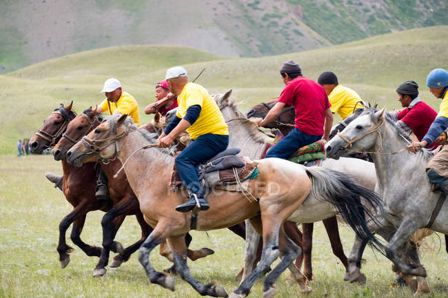 REGIÃO DE SST, QUIRGIGZSTÃO - JULHO 22, 2017: Jogos de Nômade, homens em cavalos, participantes no pólo de cabra — Fotografia de Stock