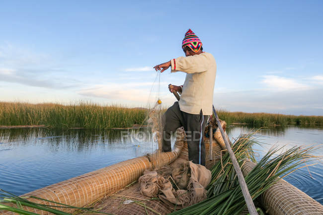 Homem local tradicionalmente pescando em barco em Puno, Peru . — Fotografia de Stock